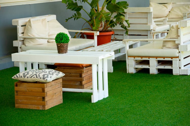 Sofá de palets con césped artificial en terraza
